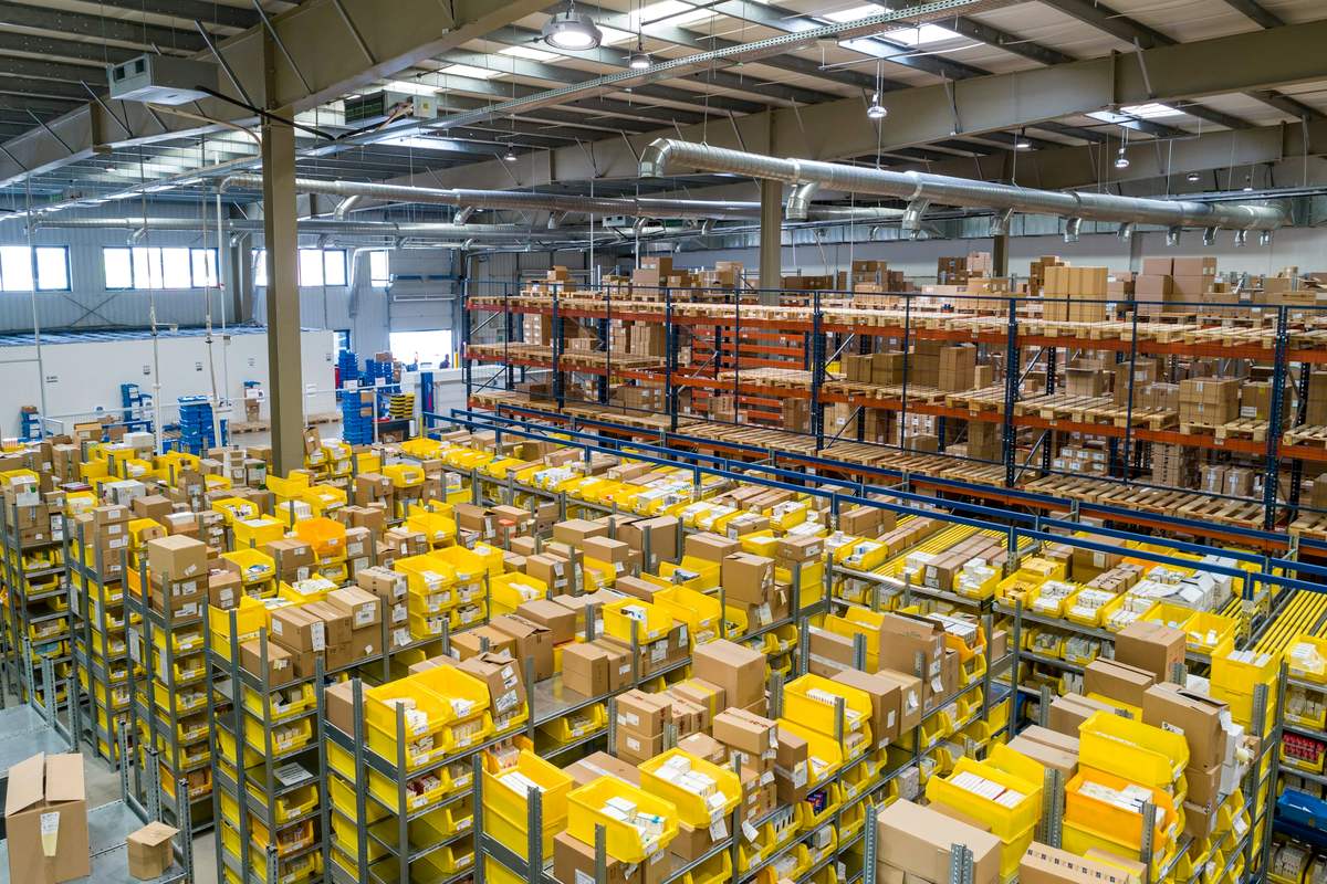 Raflarında siparişlerin hazırlandığı, kutularla dolu geniş bir e-ticaret deposu